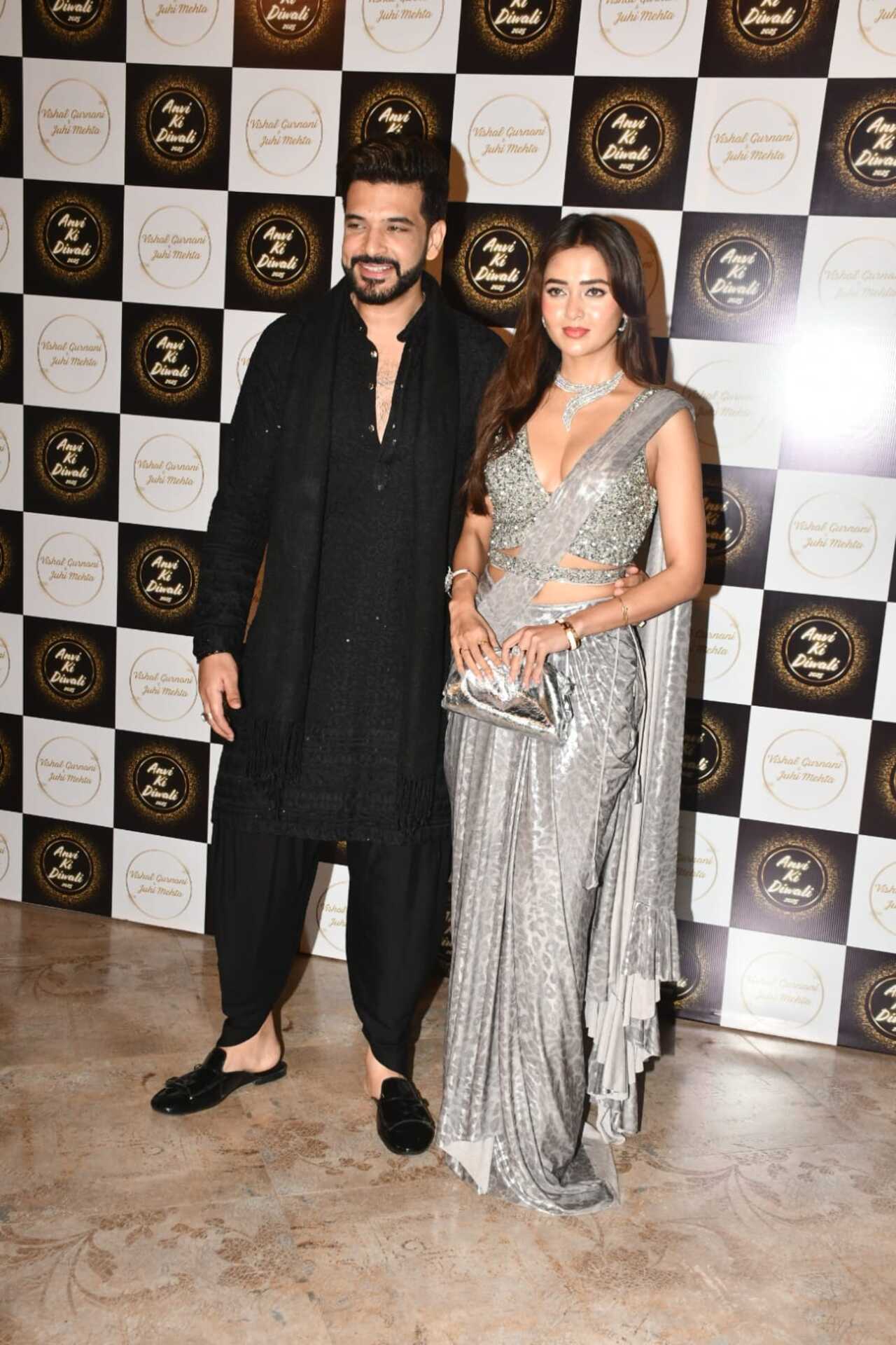 Tejasswi Prakash looked radiant in a shimmery silver saree, and Karan Kundrra complemented her in a black dhoti kurta with shimmer detailing.